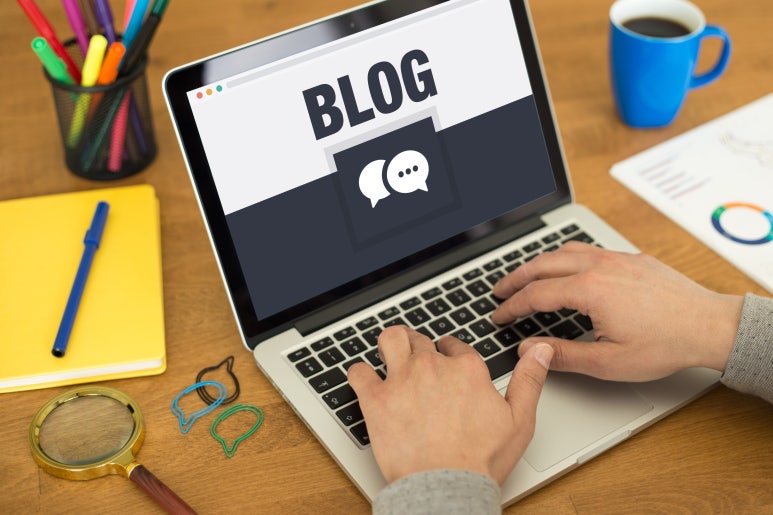노트북 화면에 'BLOG'라고 쓰여 있고, 손으로 키보드를 타이핑하는 모습