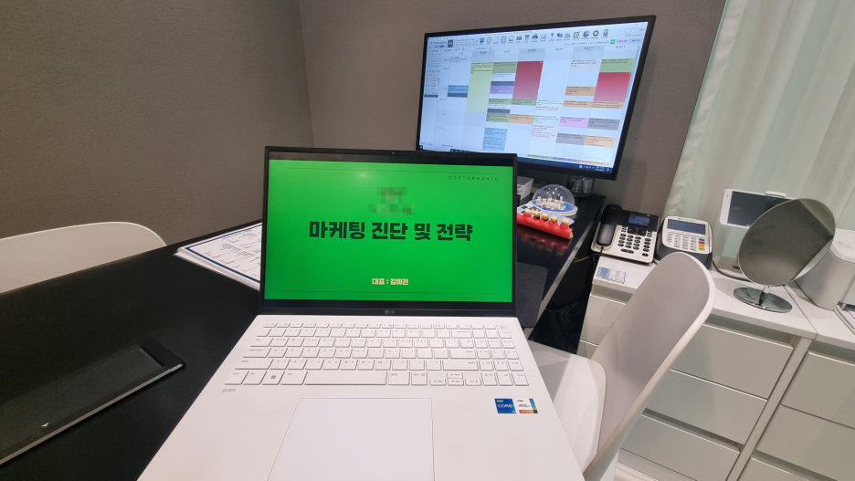 마케팅 진단 및 전략 프레젠테이션 화면이 켜진 노트북과 사무실 책상 풍경